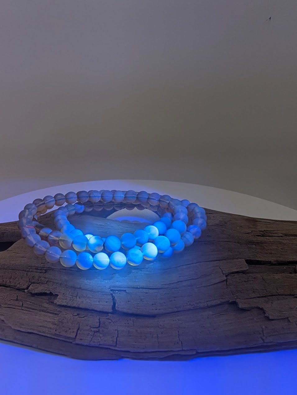 Mexican blue amber bracelet glowing bright blue with halo under UV light