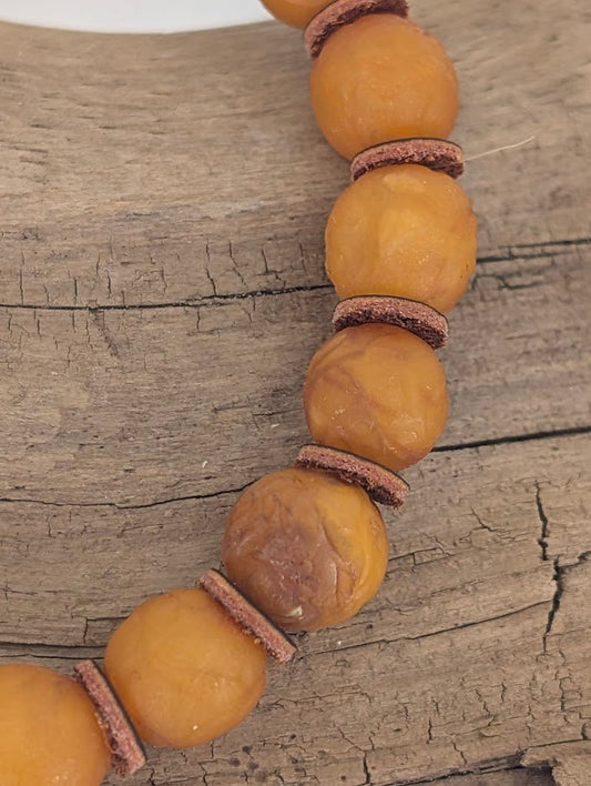 Authentic Russian Baltic Amber Bracelet 8mm – angled view under light highlighting inclusions and natural polish
