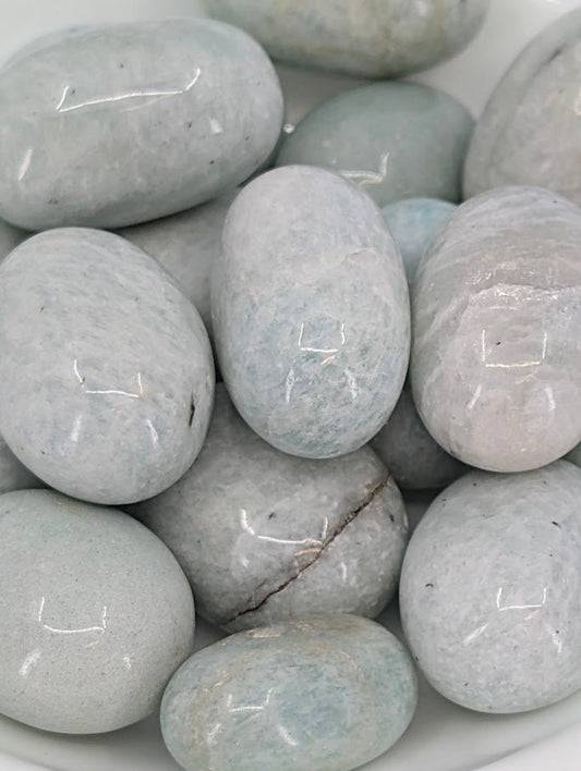 Close-up of Amazonite tumbled stones showing pale aqua color and feldspar shimmer