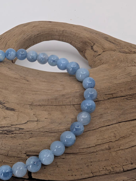 Close-up of 5mm aquamarine beads showing light blue color and polish
