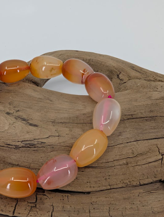 Close-up of polished barrel agate beads showing translucent banding