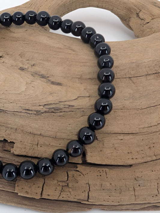 Close-up of 4mm Black Agate polished beads with deep black luster