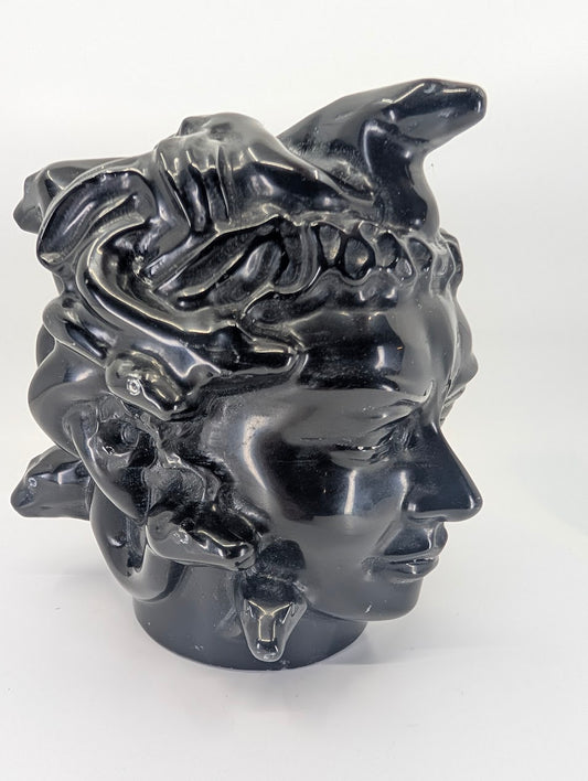 Left-angle view showing facial detail and serpentine hair