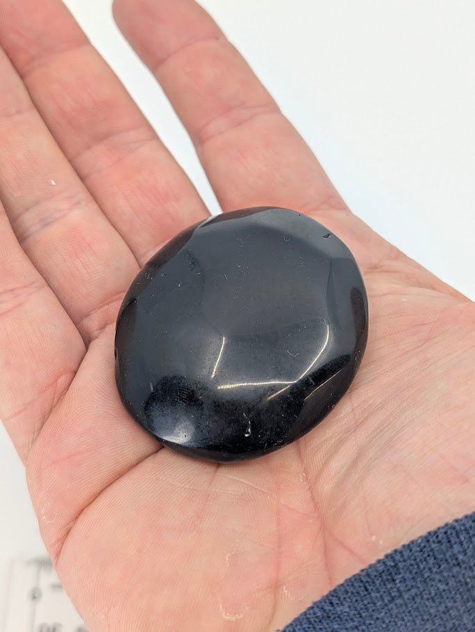 Black Obsidian Palm Stone in hand showing size