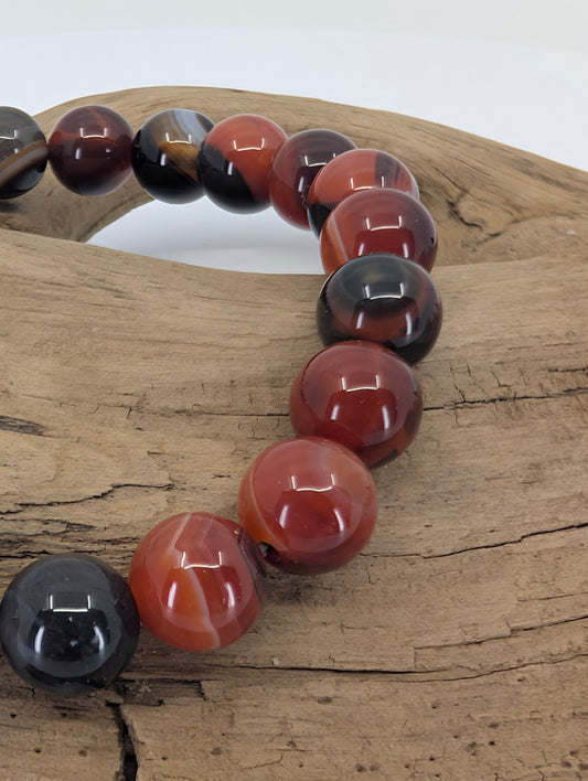 Close-up of polished Black Sardonyx beads with strong red and black banding