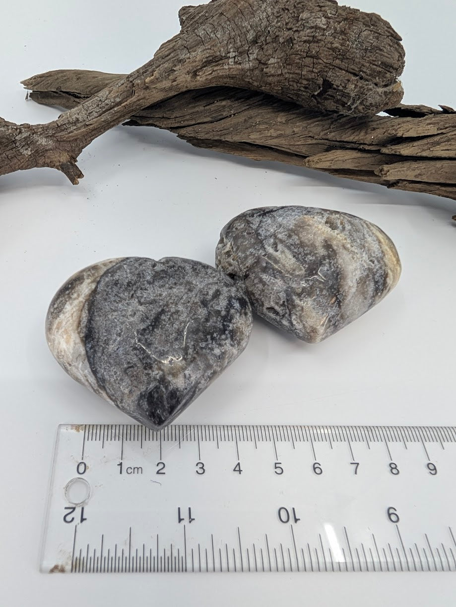 Pair of polished Black Sphalerite hearts showing cream and grey banding.