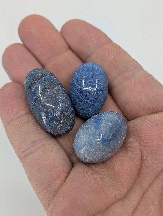 Three Blue Aventurine tumbled stones shown in hand for size reference