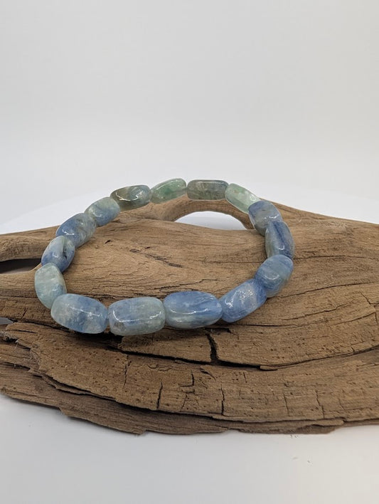 Blue Kyanite free-form bead stretch bracelet on driftwood showing water-blue tones and silky sheen