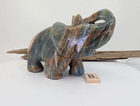 Hand-carved Blue Onyx (Banded Calcite) elephant specimen B3 from Argentina with prominent golden-cream saddle banding.