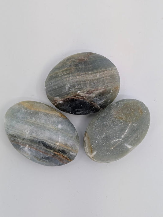 Blue Onyx palm stones grouped together highlighting blue-grey tones and natural veining