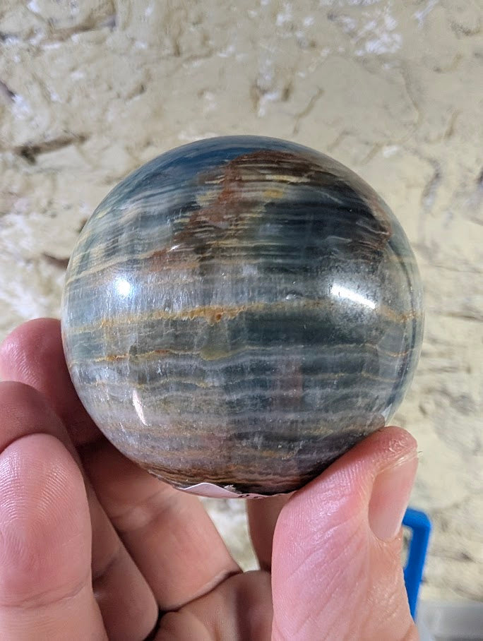 Back view of blue onyx sphere showing smooth polish and colour variations