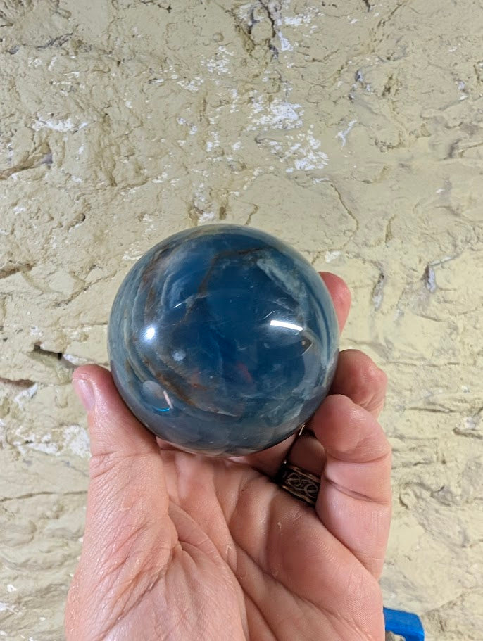 Polished top view of natural calcite with slate and blue veining