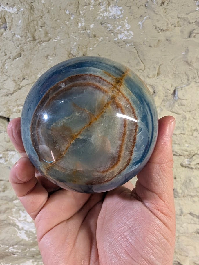 Circular iron seam ring pattern across one face of the sphere