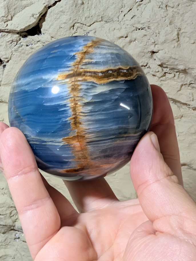 Natural banded calcite sphere with circular horizontal golden seam detail