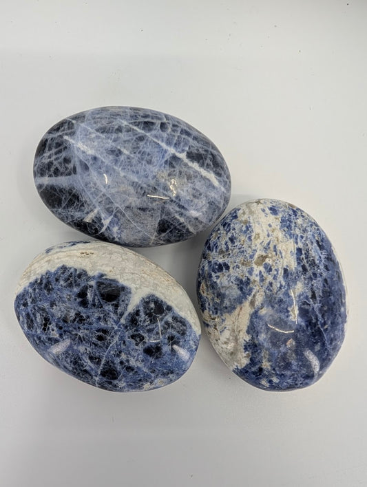 Blue sodalite palm stones close-up showing blue and white patterning