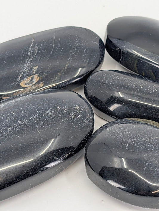 Close-up of Blue Tiger Eye Palm Stone highlighting chatoyance
