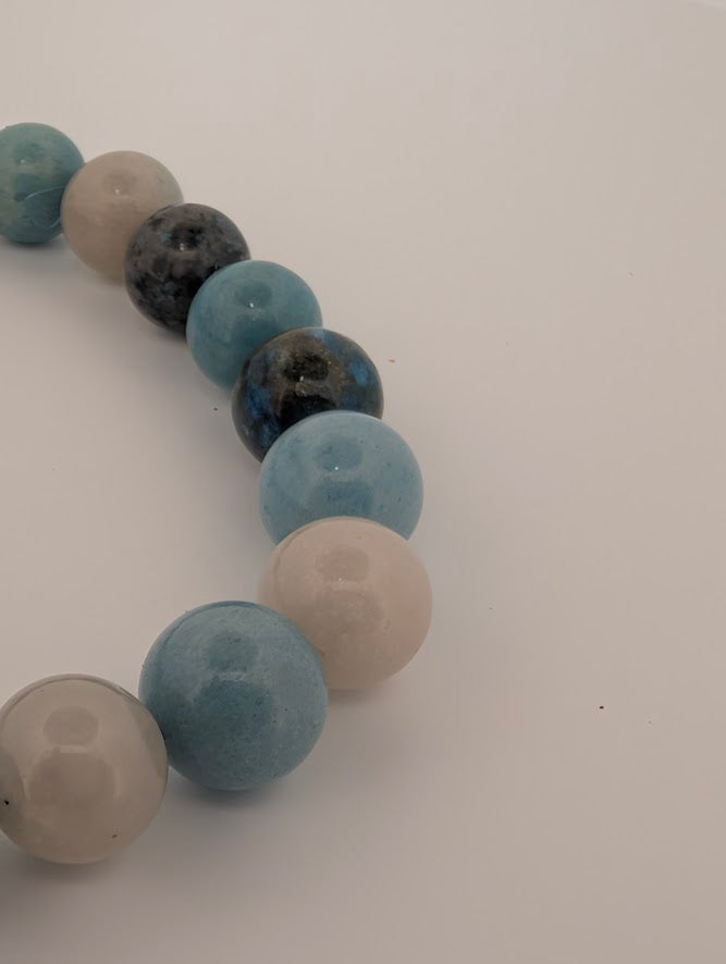 Angled macro of polished Blue Trolleite bracelet highlighting sheen and color.