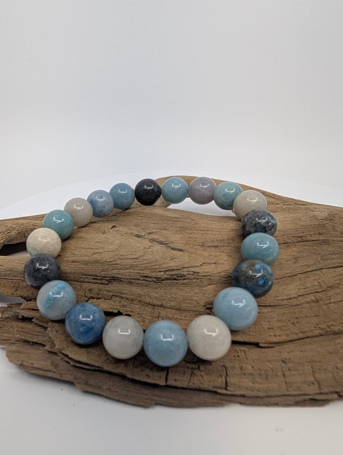Blue Trolleite 9.5mm round bead bracelet on driftwood, full bracelet view.