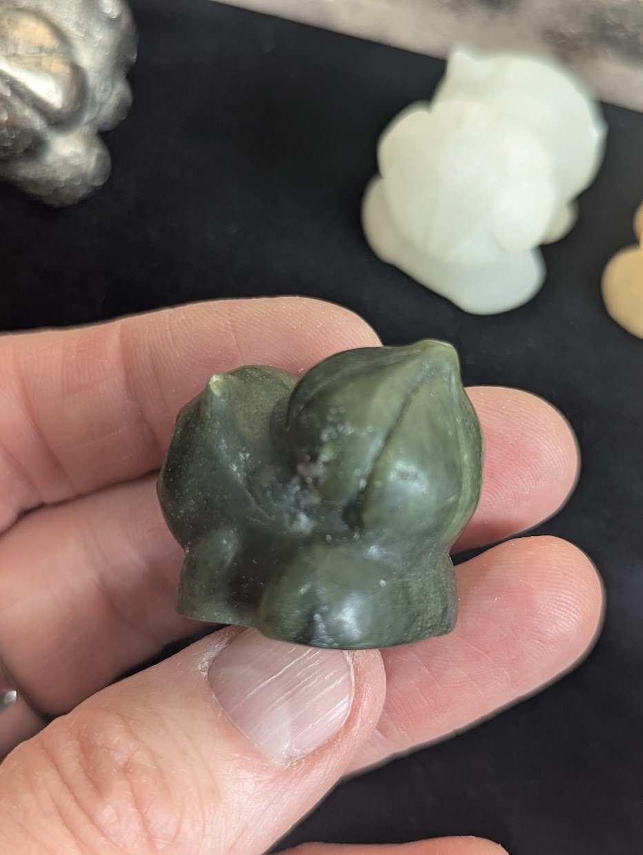 Top down view of a hand-carved Bulbasaur focusing on the natural stone texture.