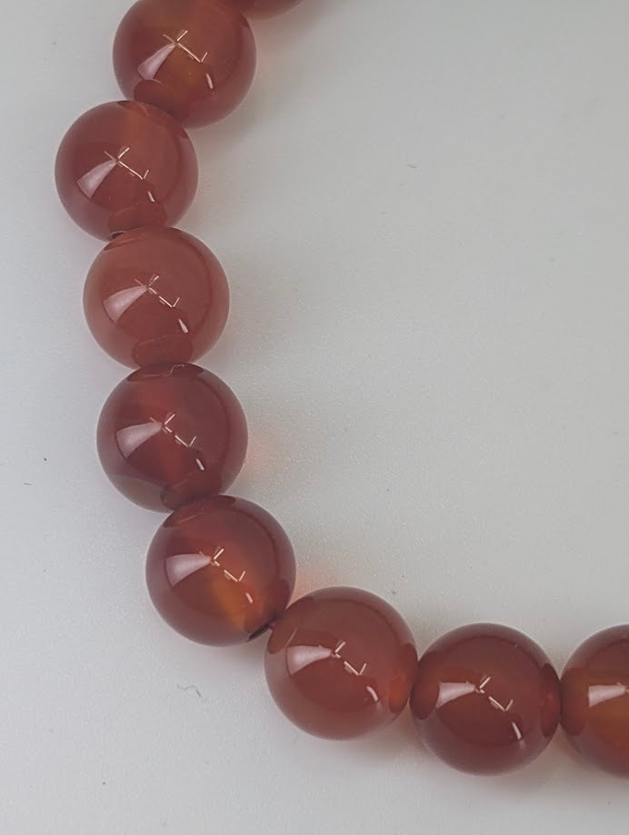 Stack of AAA Carnelian bracelets demonstrating uniform tone and warm amber-red hue