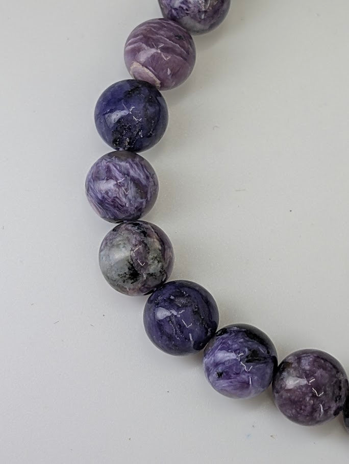 Detailed macro of charoite beads showing fibrous chatoyance