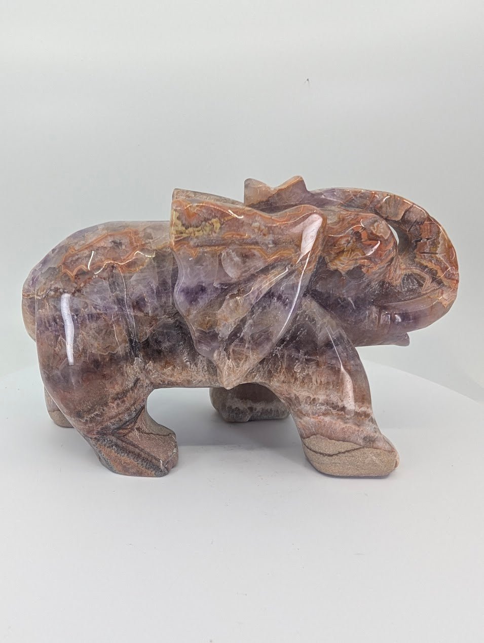 Closeup angled view of Chevron Amethyst elephant with banded quartz