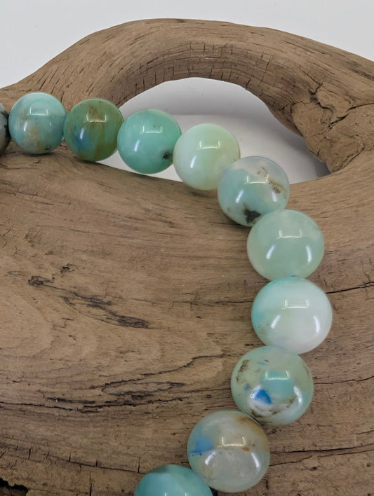 Close-up of 8mm Chrysocolla beads highlighting natural turquoise patterns and translucent quartz matrix.