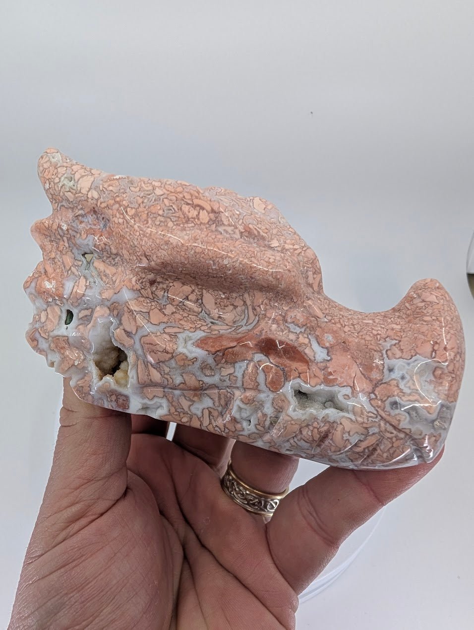 Handheld view of Cotton Candy Agate Dragon Head Variant B highlighting polish, texture, and natural vugs