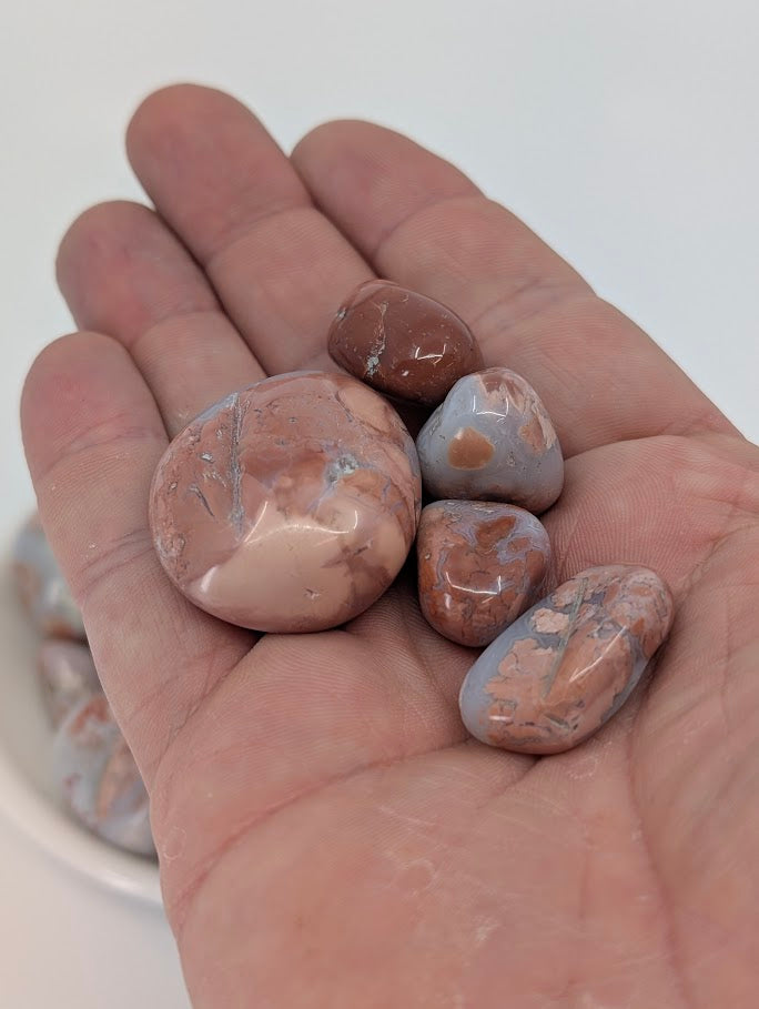 Cotton Candy Agate tumbled stones in hand for size reference