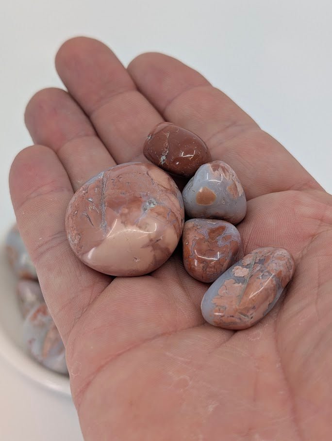 Cotton Candy Agate tumbled stones in hand for size reference