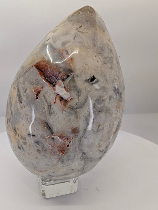 Side view of crazy lace agate egg showing layered banding and movement