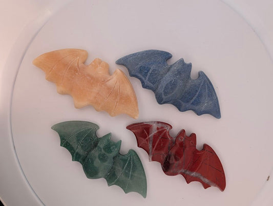 Top view of four crystal bat carvings