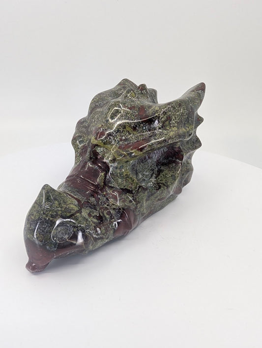 Side profile of Dragon Blood Stone dragon head showing red and green natural patterning