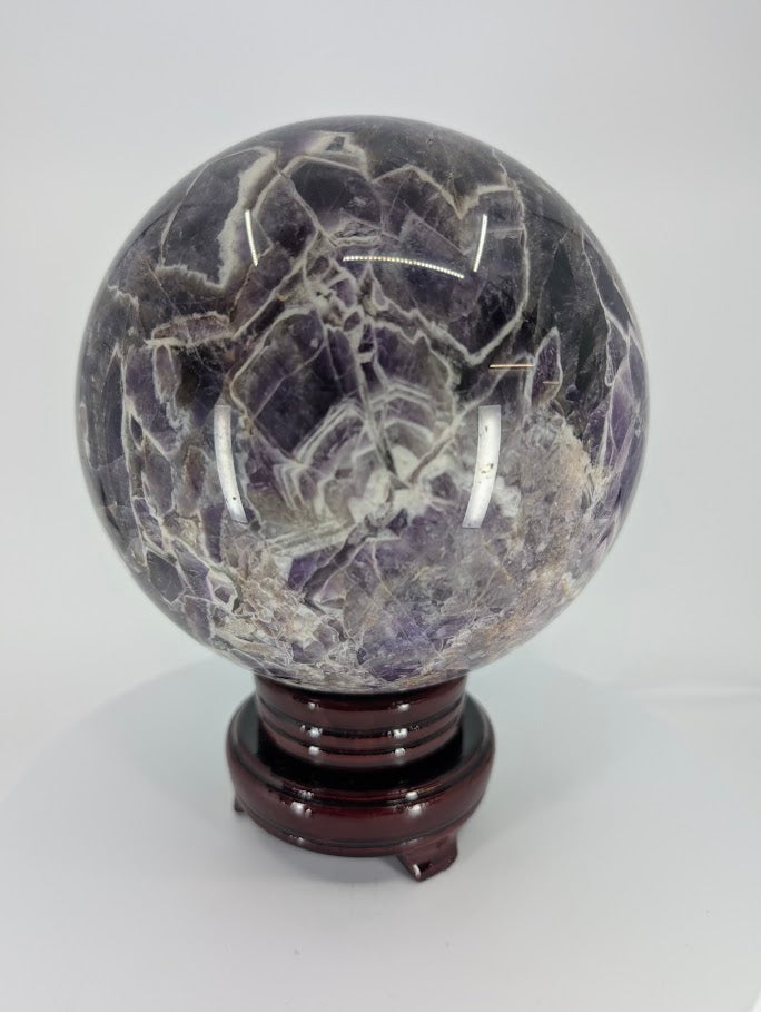 Dream Amethyst sphere showing deep violet chevron bands and polished surface