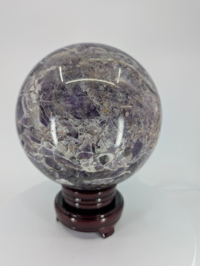 Close-up of Dream Amethyst sphere surface with natural texture and polish reflection