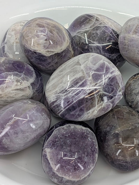 Close-up of Dream Amethyst tumbled stones showing purple and white quartz layering