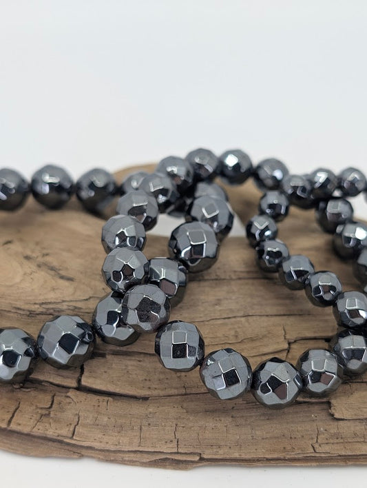 Close-up of faceted hematite beads showing mirror-like reflection
