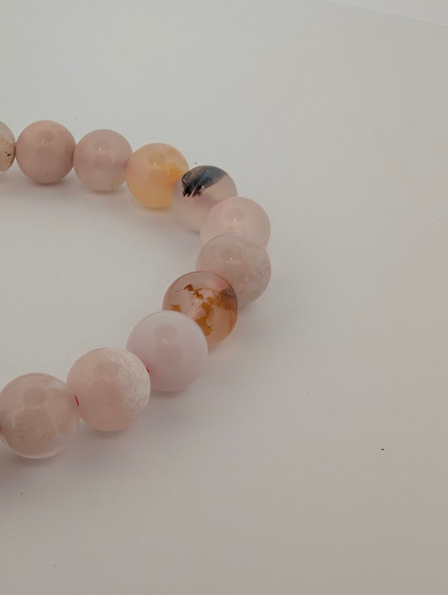 Angled close-up highlighting honey and peach accents within Flower Agate beads
