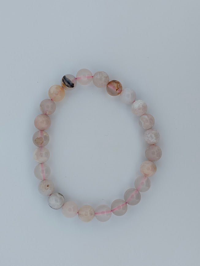 Overhead view of Flower Agate 8mm bracelet on light background