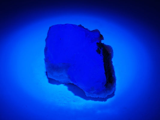 Strong blue fluorescence of Yaogangxian Porcelain Fluorite under long-wave UV light confirming natural mineral authenticity.