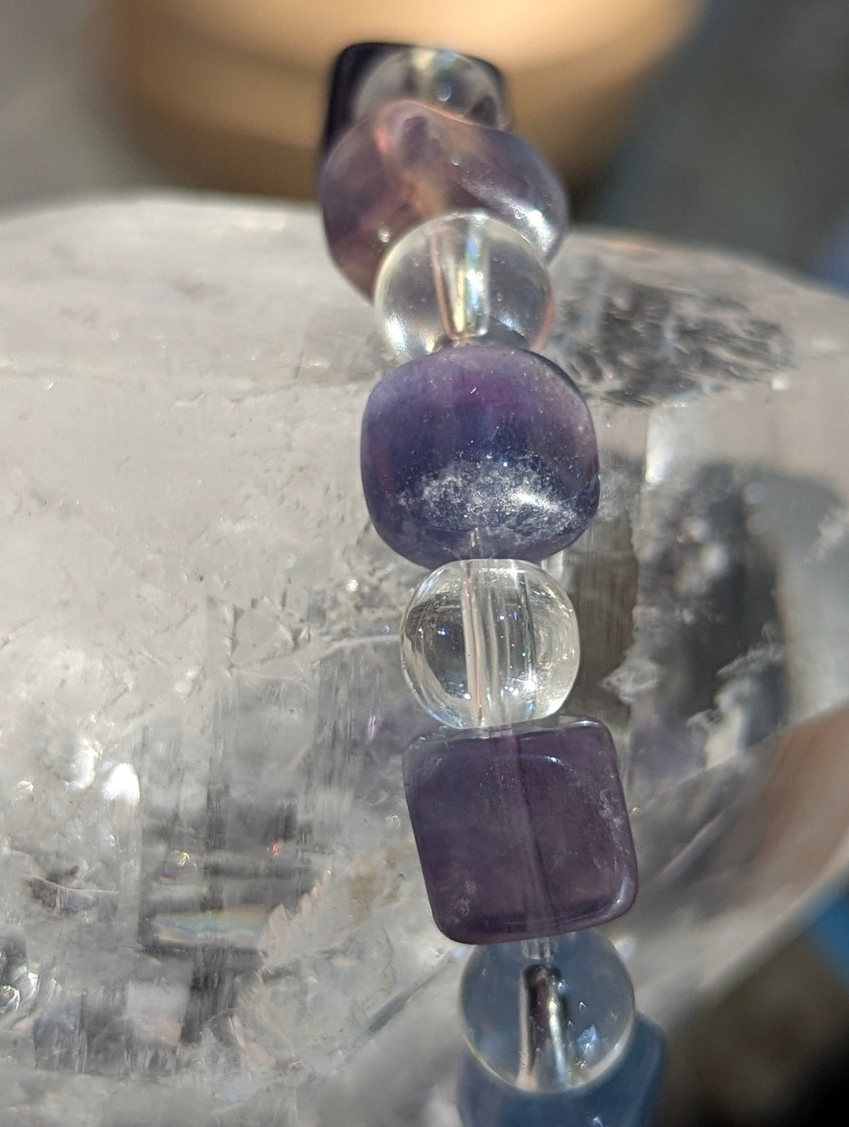 Macro close-up view of polished 9 mm blue fluorite cubes and 8 mm clear quartz spheres, highlighting the vitreous surface luster and exceptional optical clarity of the stones.