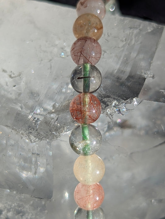 Macro close-up of 6mm Garden Quartz beads, highlighting the clear host quartz and intricate, natural moss-like mineral inclusions inside.