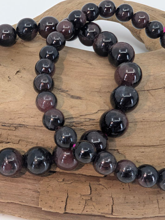 Close-up of Garnet with Astrophyllite beads showing metallic inclusions