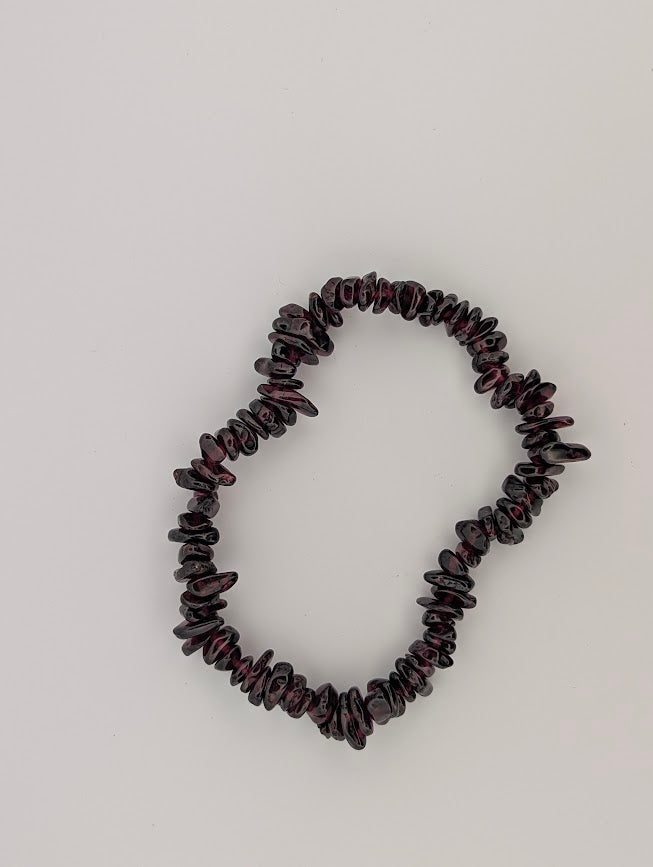 Garnet chip bracelet flat lay with tumbled pieces on stretch cord