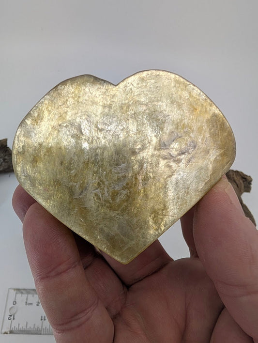 Hand holding a large 100g Golden Mica heart showing metallic flash.