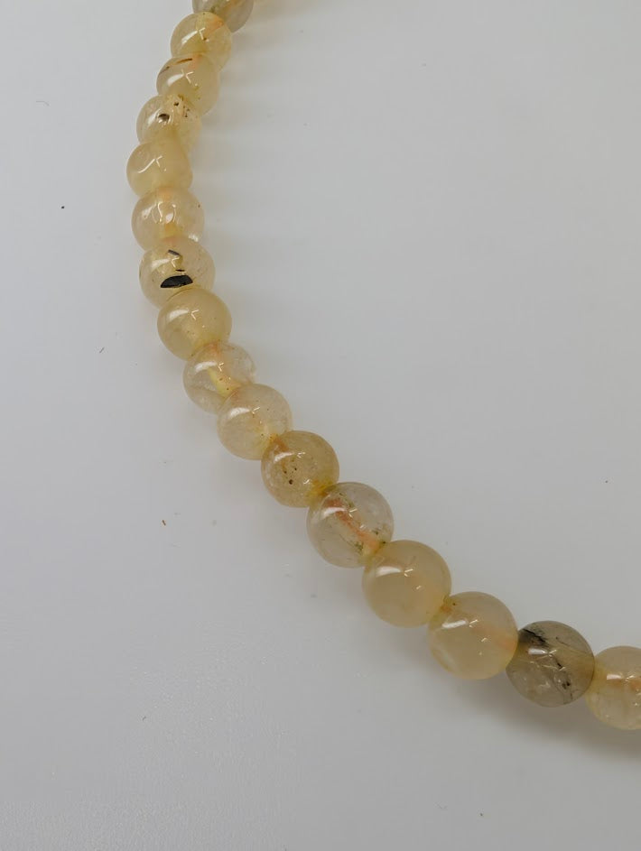 Detailed view of polished Golden Rutile Quartz beads