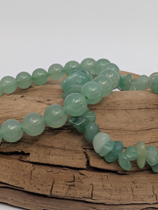 Close-up of green aventurine 8mm round and chip beads, polished and tumbled