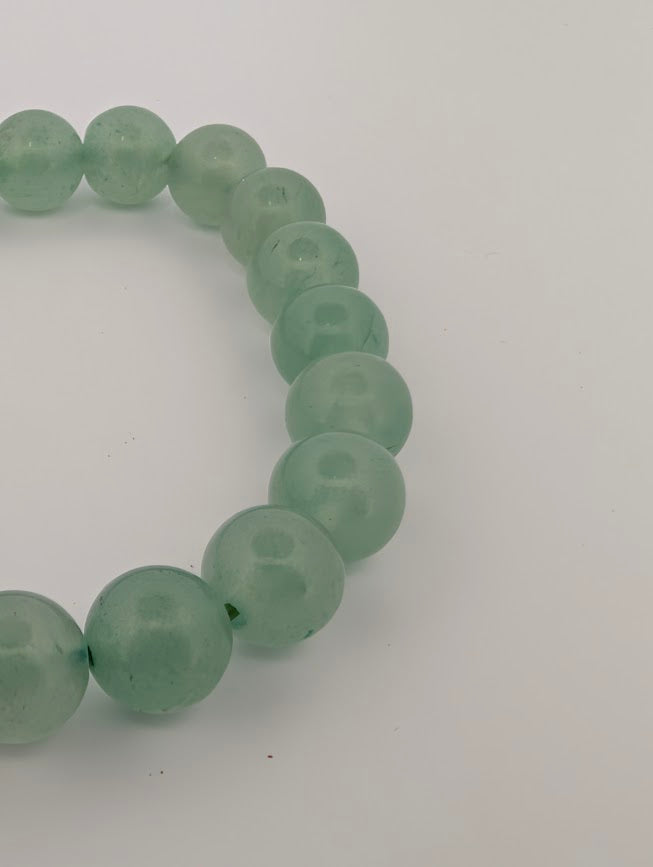 Macro detail of green aventurine 8mm round beads showing soft translucence