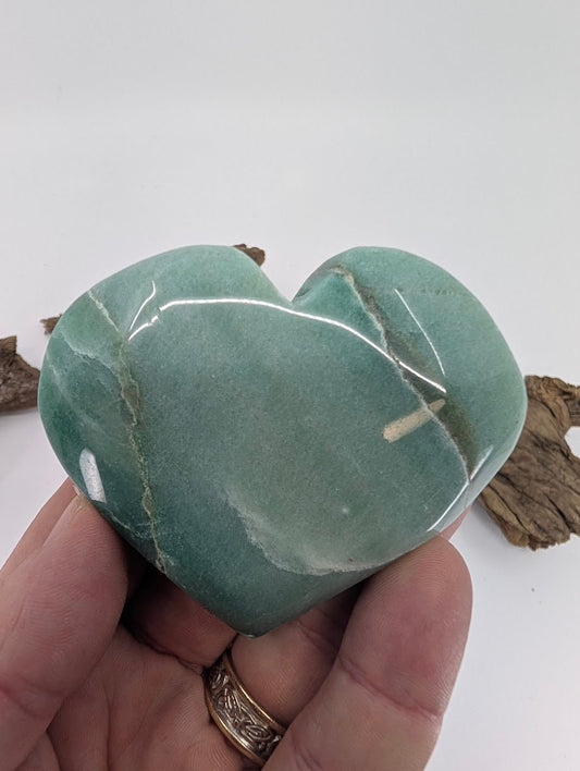 Hand holding a large 170g Green Aventurine heart showing size and polish.