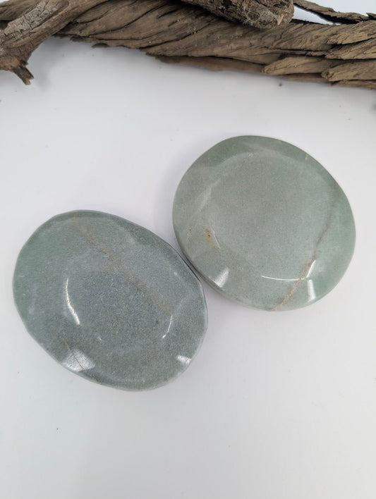 Group of large green aventurine palm stones showing natural color variation